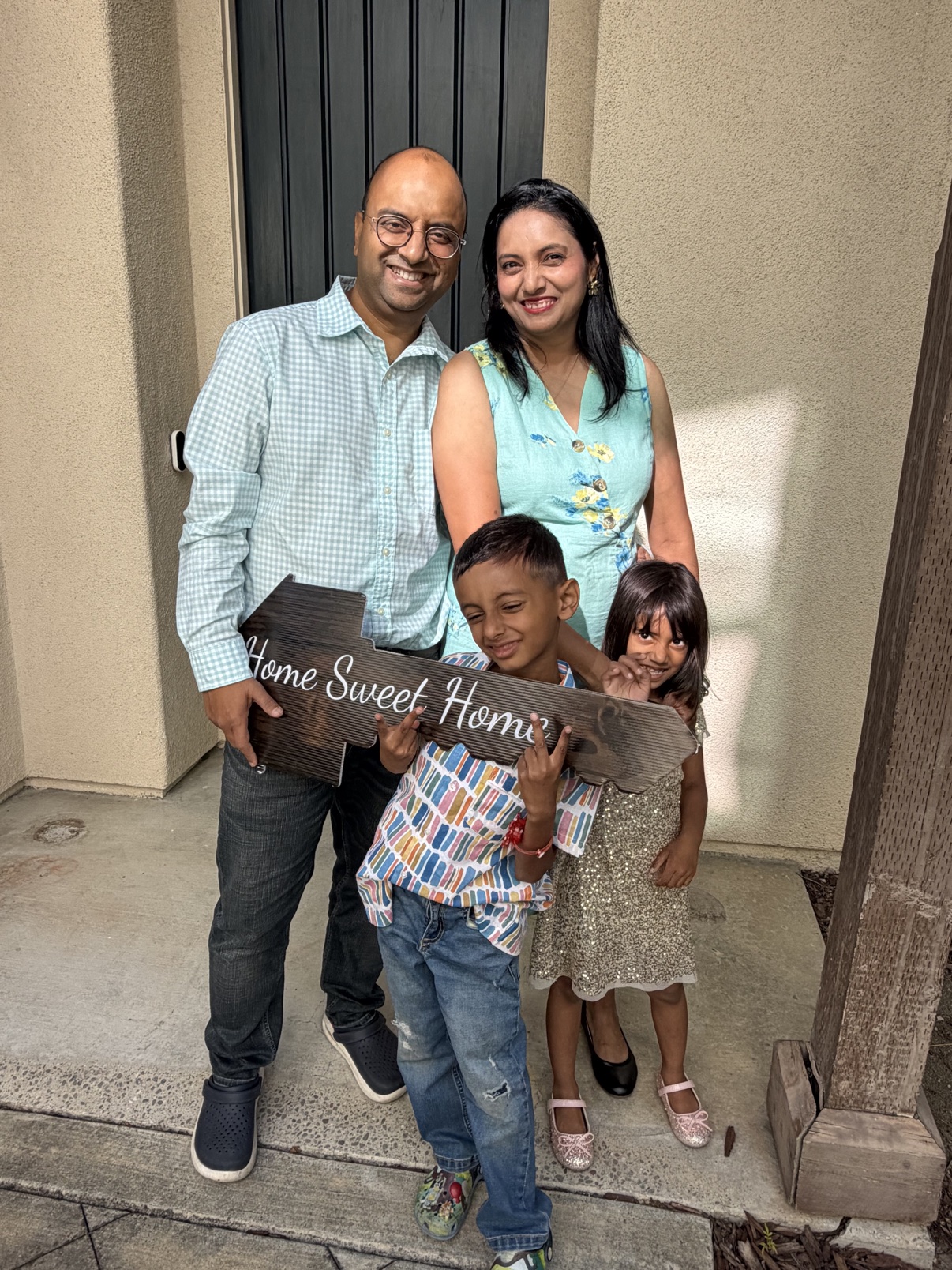 Harshit K. and his family celebrating in front of their new home