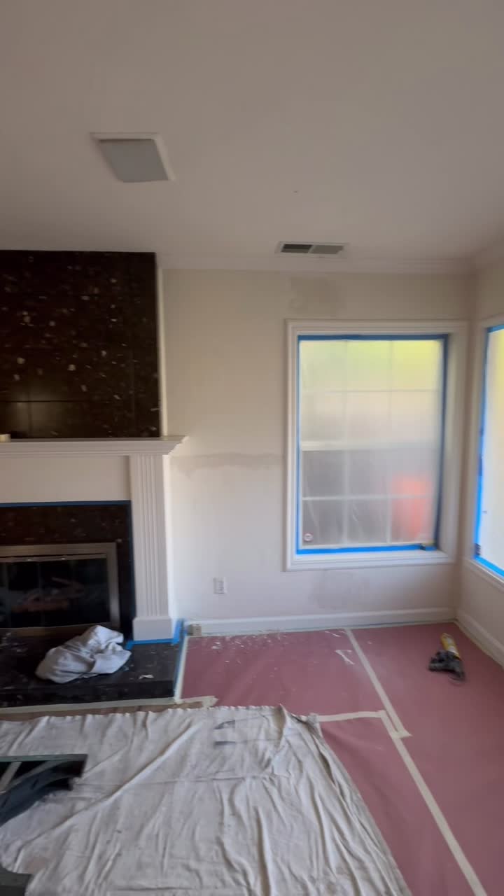 Saranap living room during paint preparation with covered floors and taped windows